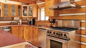 Una cocina con armarios de madera, una estufa de acero inoxidable y un lavabo.