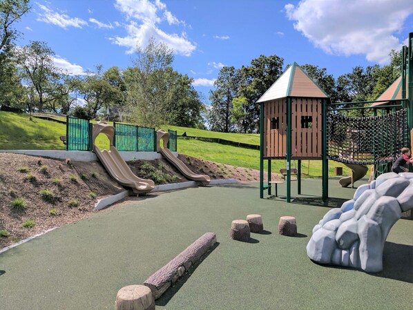 A playground with slides, a climbing structure, and a small seating area.