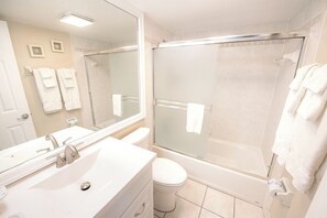 Een badkamer met een wastafel, toilet en douchecabine.