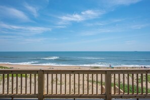 A wooden deck overlooking a beach with waves, a clear sky, and distant ships. - 449 Ocean-Front Amazing Views & Easy Beach Access (Nags Head)