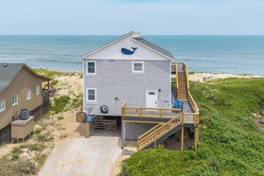 A two-story building with a wooden deck and a staircase leading to the upper level. - 449 Ocean-Front Amazing Views & Easy Beach Access (Nags Head)
