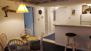 A compact kitchen with a dining area, featuring a round table with chairs, a small bar area, and a clock on the wall. - The Resort with it all - Beautiful Myrtle Beach Resort Condominium/FLEX Policies (Myrtle Beach)