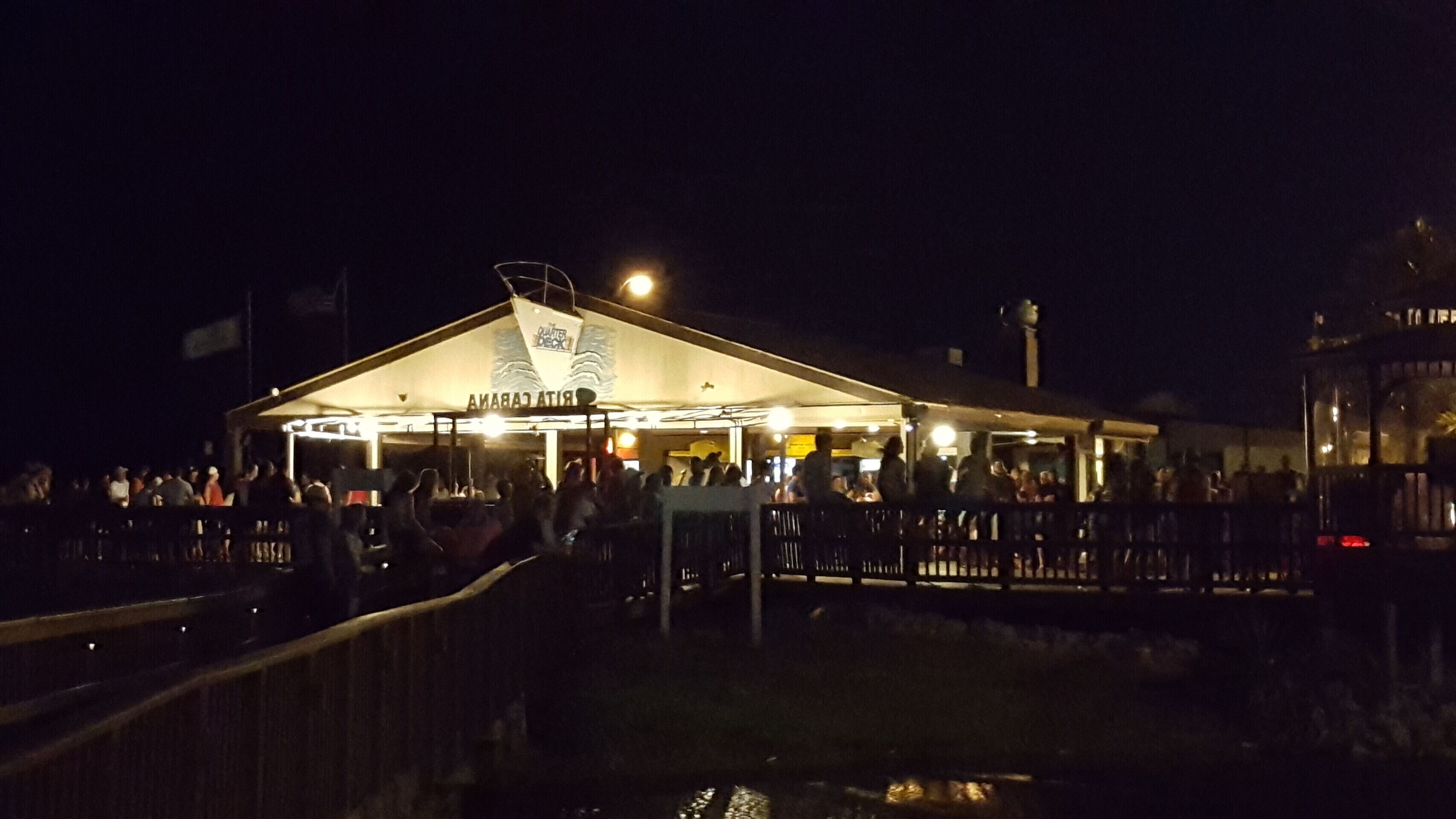 Ein Restaurant am Wasser mit einer überdachten Sitzgelegenheit und Blick auf das Wasser.