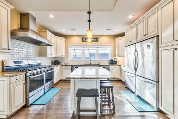 Enjoy cooking in this well-equipped kitchen with a central island, double ovens, and a range hood.