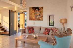 Una sala moderna con un sofá, una mesa de centro y un sillón decorativo.