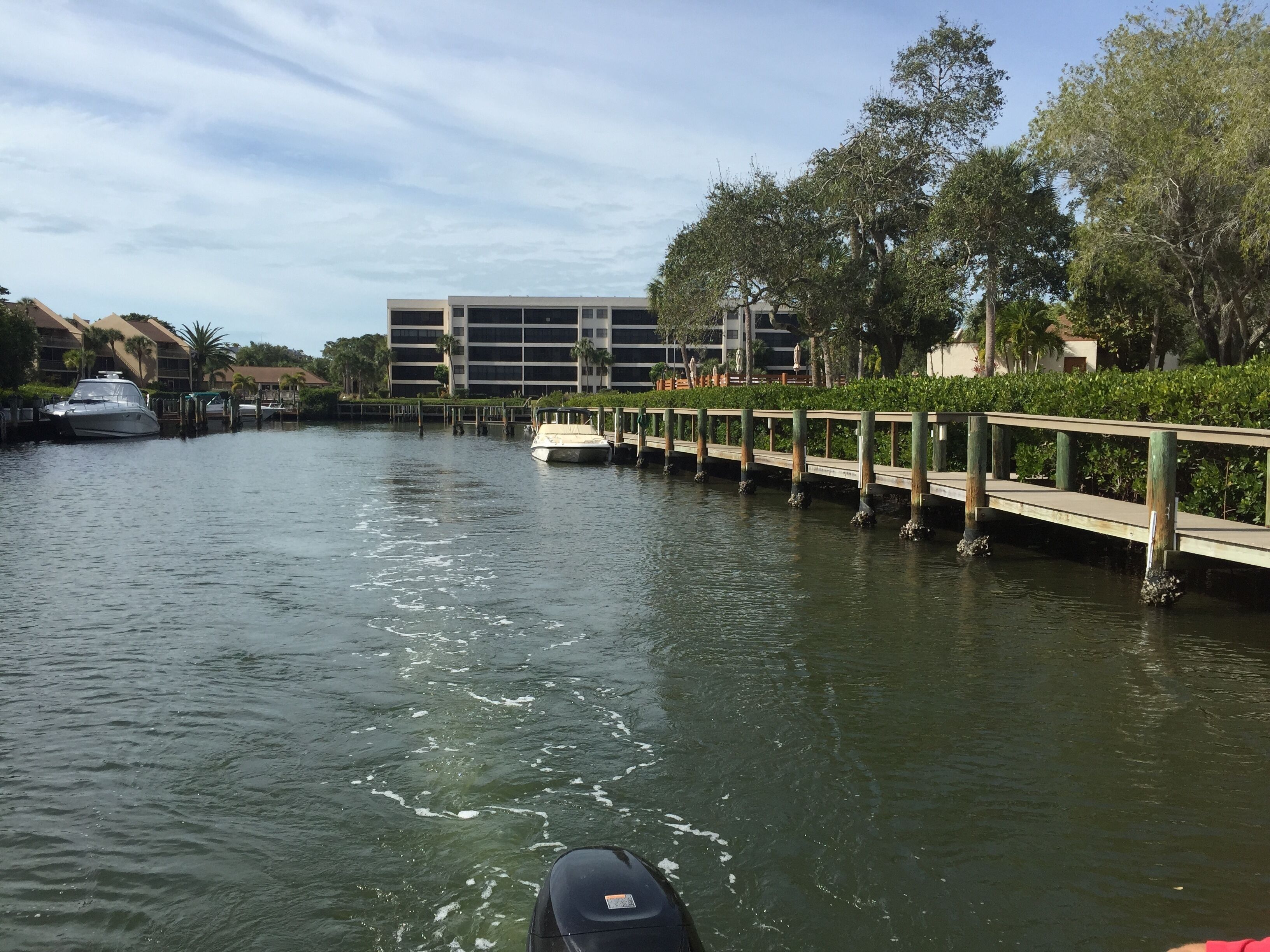 A canal with a wooden dock and a boat.