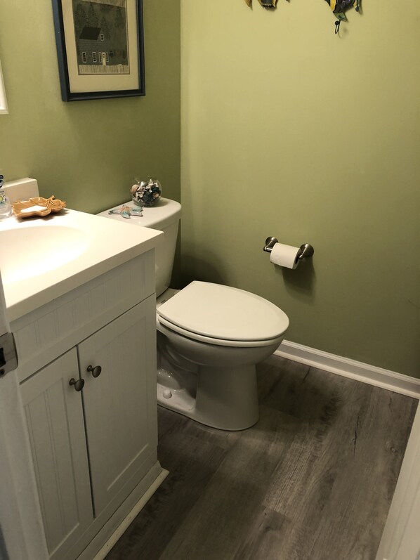 A bathroom with a toilet, sink, and cabinet. - Barb's Three Wishes! Sun, Sand, Siesta! (Sarasota)