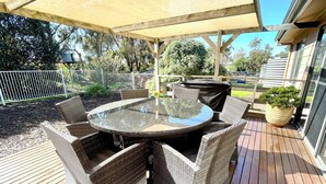 A covered outdoor patio with a round glass table surrounded by wicker chairs, a barbecue grill, and a potted plant. - Al-Pac-Em Inn - Farm Stay (Kingscote)