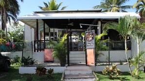 A restaurant with outdoor seating, a covered entrance, and a signboard. - Atlantic One 2 Bedroom (Costambar)