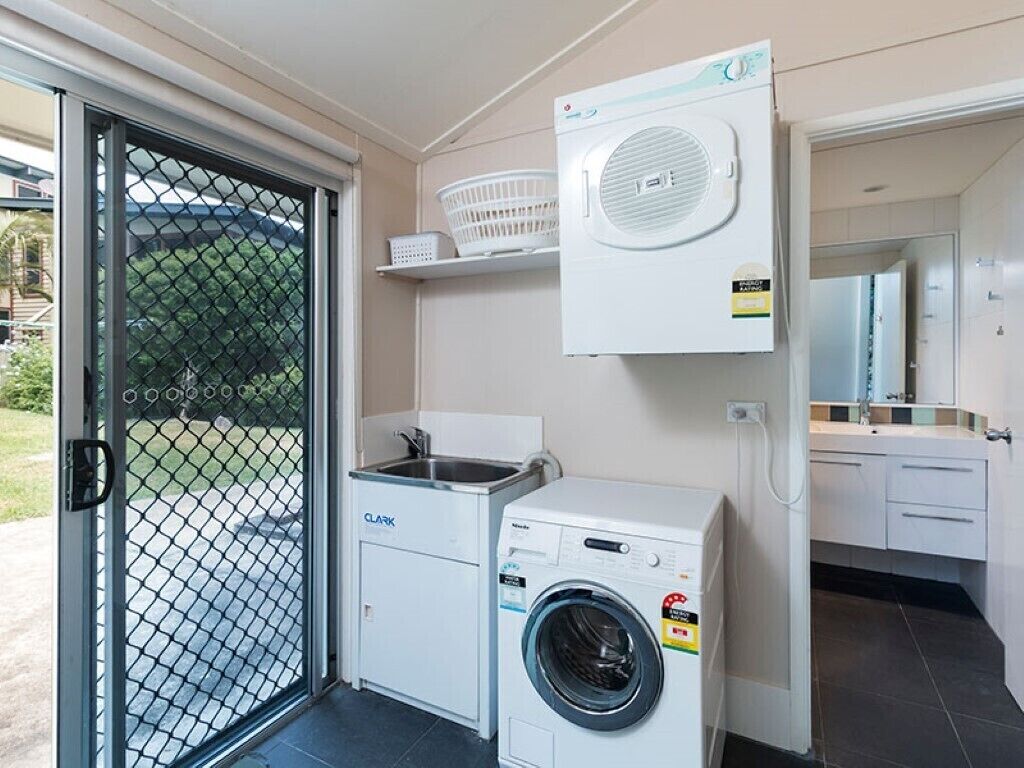 A compact laundry area with a washing machine, a dryer, and a sink.