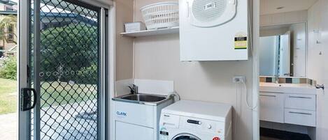 A compact laundry area with a washing machine, a dryer, and a sink.