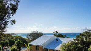 A house with a metal roof, a satellite dish, and a view of the ocean. - Family beach house across the road from Cylinder Beach. (Point Lookout)