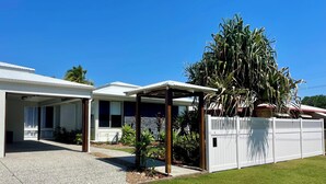 A modern two-story house with a covered patio, a fenced yard, and a large tree. - Renovated Beach House in the Heart of Mooloolaba (Mooloolaba)