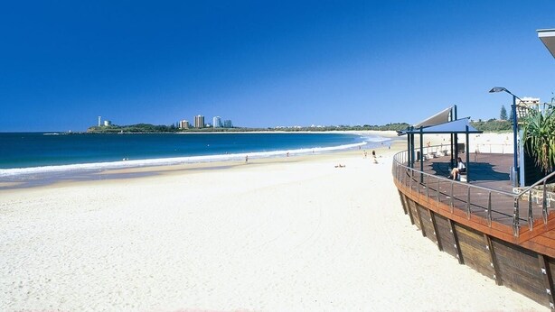 A beach with a wooden boardwalk and a covered seating area. - Renovated Beach House in the Heart of Mooloolaba (Mooloolaba)