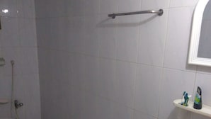A bathroom with a toilet, sink, and a mirror.