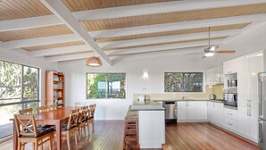 A spacious kitchen with wooden flooring, white cabinetry, and a central island.