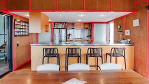 A modern kitchen with a central island, stainless steel appliances, and a red and white color scheme.