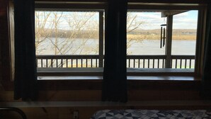 A room with a large window overlooking a body of water and a dock. - ‘’Castle Colucci’’Magnet Indiana,a slice of Heaven where the world stands still. (Magnet)