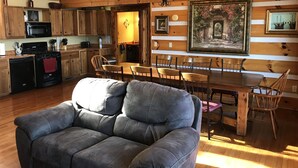 A cozy cabin interior with a dining area, kitchen, and a comfortable seating area. - ‘’Castle Colucci’’Magnet Indiana,a slice of Heaven where the world stands still. (Magnet)