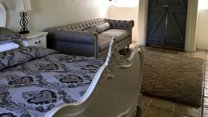 Un dormitorio con cama, mesita de noche, cómoda y un armario espacioso.