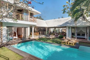 A two-story house with a swimming pool, outdoor seating, and a covered patio area. - Tranquil 4BR Villa, Pool & Rooftop, Next Berawa (Umalas)