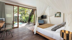 Ein Schlafzimmer mit Bett, Fernseher, Schreibtisch und Stuhl.