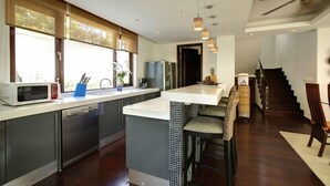 Una cocina moderna con una isla grande, electrodomésticos de acero inoxidable y vistas al exterior.