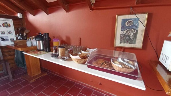 Una barra de desayuno con diversos alimentos, como pan, pasteles y bebidas.