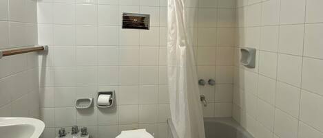 Une salle de bain équipée d’un bidet, de toilettes et d’une baignoire.
