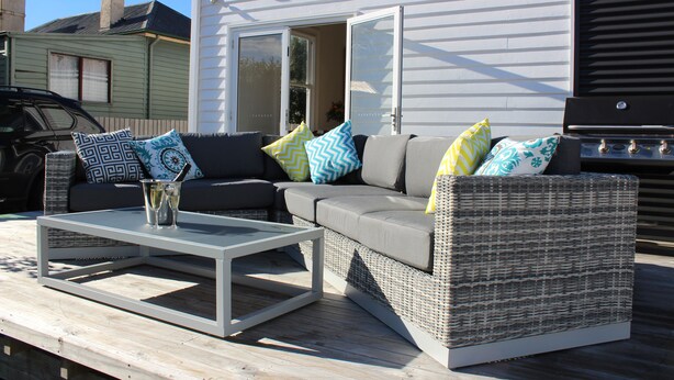 An outdoor seating area with a wicker sofa, a white coffee table, and a grill. - Signature on Gunn. Devonports finest executive holiday home. (Devonport)