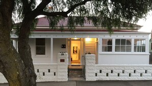A white two-story house with a number 29 sign at the entrance, a front porch, and a small front yard. - Signature on Gunn. Devonports finest executive holiday home. (Devonport)