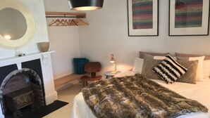 A bedroom with a bed, a fireplace, a hanging light fixture, and two framed artworks on the wall. - Signature on Gunn. Devonports finest executive holiday home. (Devonport)
