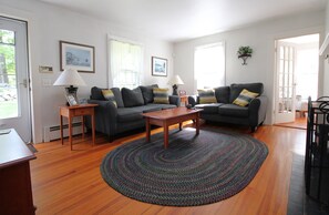 A living room with two sofas, a coffee table, and a rug. There are two lamps on side tables, and a framed picture on the wall. - 4BR Cape Style Near Saints Landing and Paines Creek (2086) (Brewster)