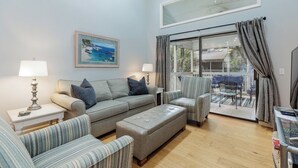 A living room with a sofa, armchairs, a coffee table, and a dining area with a table and chairs.