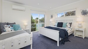A bedroom with a white bed, a nightstand, a window, and a door. - Spacious Sorrento Retreat (Sorrento)