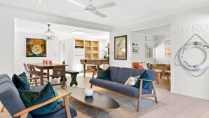 Un salon moderne comprenant un canapé, des fauteuils, une table basse et un coin repas avec une table et des chaises.