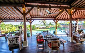 A covered outdoor area with a pool, wooden furniture, and a view of a lush landscape. - 2 bedroom private villa with pool in Ubud, Bali (Ubud)