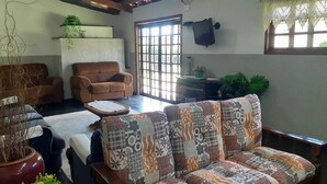 Un salon avec un canapé, des fauteuils, une table basse et une plante en pot.