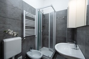 Une salle de bain moderne avec une douche à l’italienne, des toilettes et un lavabo.