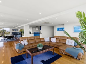 A spacious living area with a large L-shaped leather sofa, a coffee table, and a dining table with chairs. - Top Class Rye Getaway with Pool (RYE)