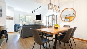 Una cocina moderna con una mesa de comedor, sillas y un frutero.