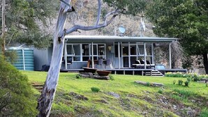 A single-story house with a porch, a satellite dish, and a small deck. - Riverside House on the beautiful Howqua River (Howqua)