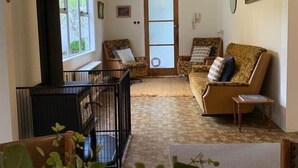 Una sala de estar acogedora con chimenea, dos sofás, una mesa de centro y un ventanal grande.