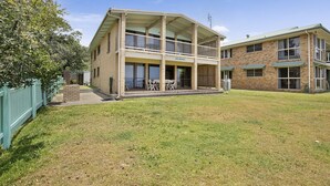 A two-story building with a covered patio area and a fenced yard.