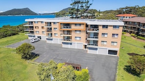 Situated near a body of water, this building offers a scenic view and features a flat roof, large windows, and balconies.