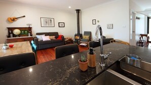 Una sala de estar moderna con un sofá, una mesa de comedor y una zona de cocina con estufa.