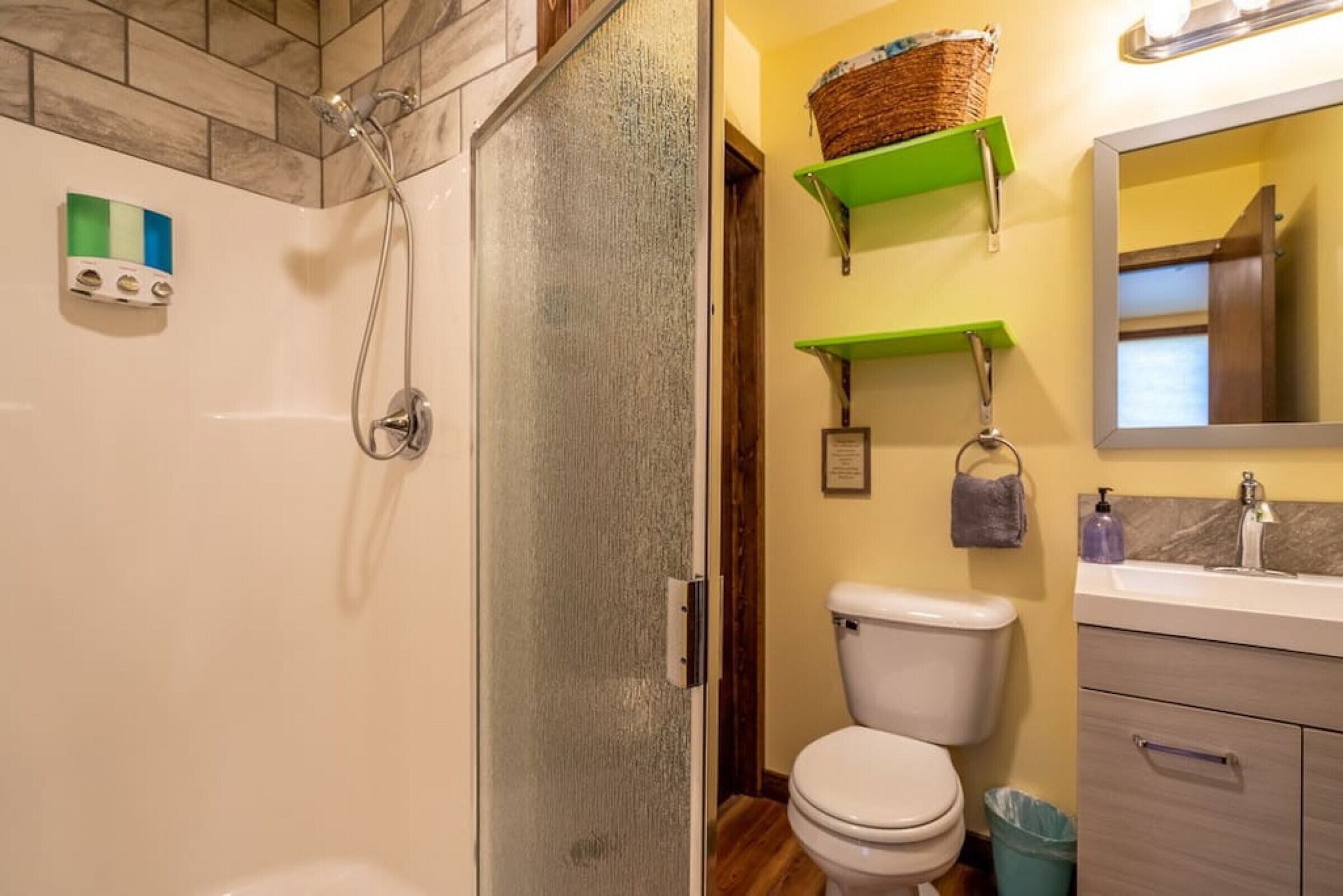 A bathroom with a shower, toilet, and vanity.