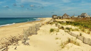 A sandy beach with wooden fences and houses in the background. - The Folger House on historic Academy Hill, Nantucket (Nantucket)