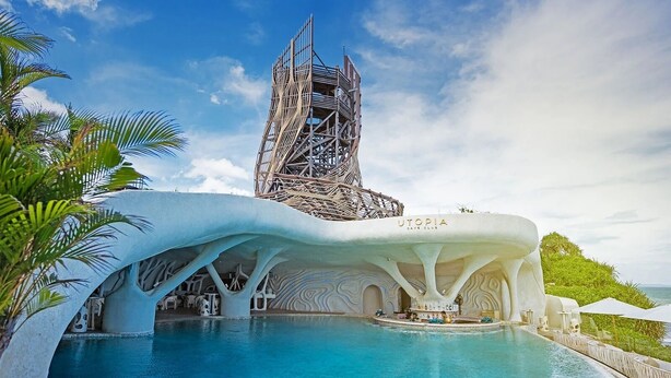 Ein modernes Hotel mit markanter Architektur, das einen großen Pool und einen unverwechselbaren Turm beherbergt.