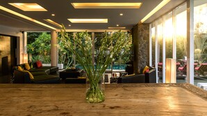 Ein stilvoller Lounge-Bereich mit einem Holztisch, Sofas und einer großen Pflanzvase.